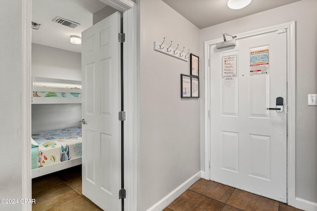 entryway with dark tile floors