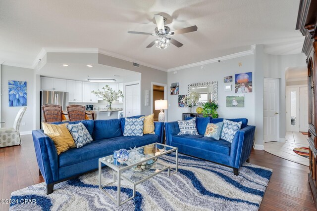 living room featuring crown molding, ceiling fan, and dark hardwood / wood-style floors