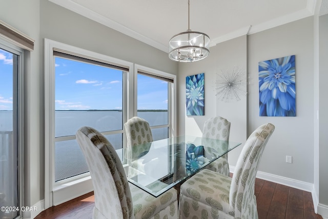 dining room featuring a chandelier, ornamental molding, a water view, and dark wood-type flooring