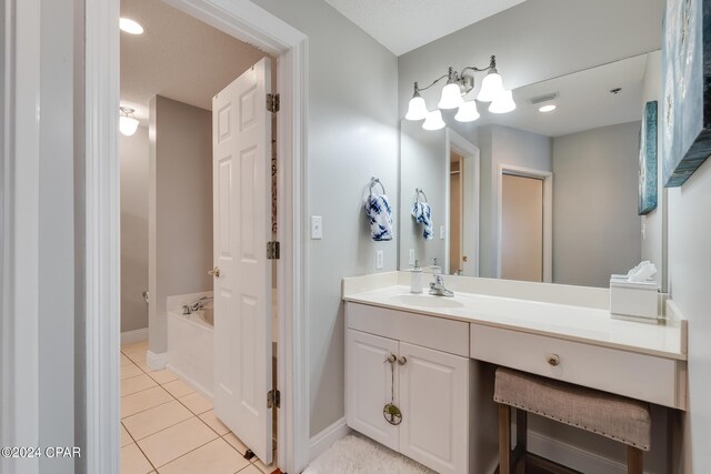 bathroom with tile patterned flooring, a bath, and vanity