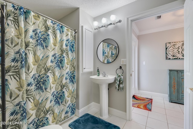 bathroom featuring curtained shower, tile patterned flooring, and a textured ceiling