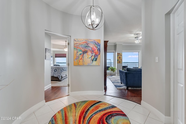 hallway featuring a notable chandelier, crown molding, and light hardwood / wood-style flooring