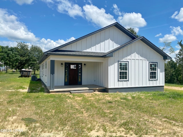 view of front of house featuring a front yard, covered porch, and central air condition unit