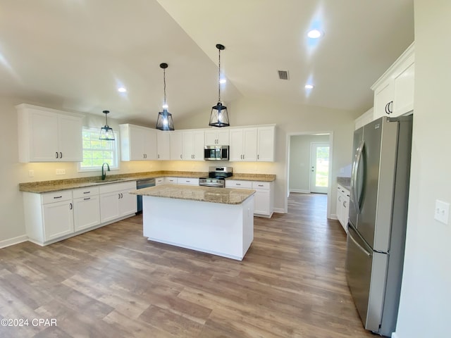 kitchen featuring visible vents, white cabinets, a kitchen island, stainless steel appliances, and a sink