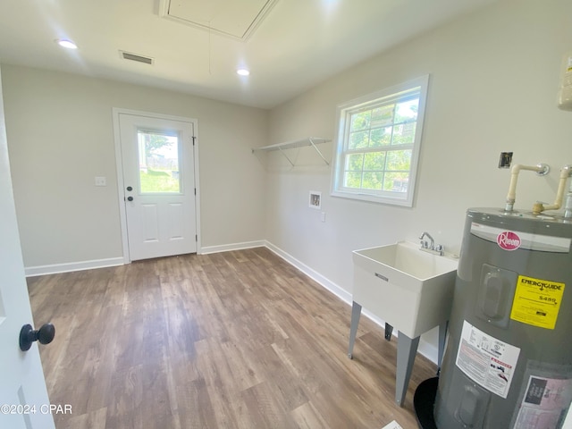 clothes washing area featuring laundry area, attic access, wood finished floors, electric water heater, and washer hookup