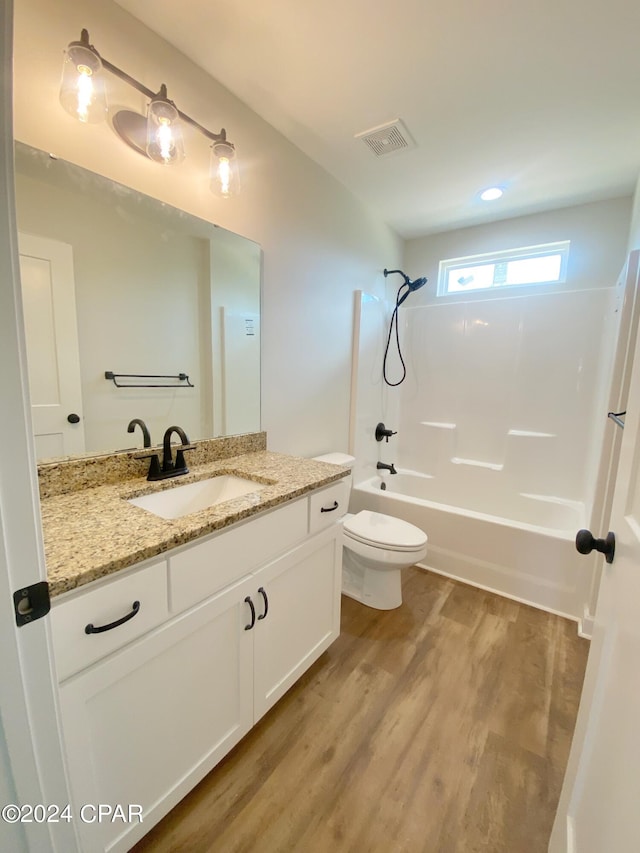 full bath featuring shower / bath combination, visible vents, toilet, vanity, and wood finished floors