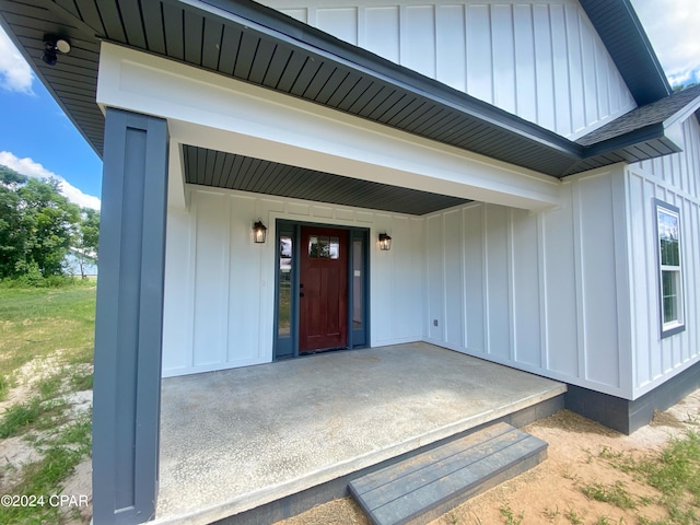 doorway to property featuring board and batten siding and a shingled roof