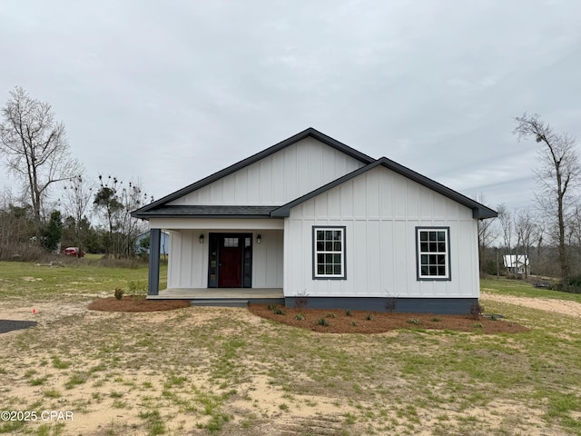 view of front facade with a porch, board and batten siding, and a front yard