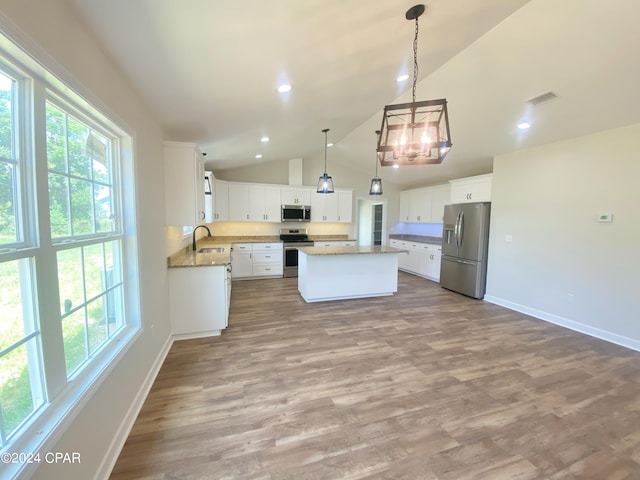 kitchen featuring visible vents, a kitchen island, appliances with stainless steel finishes, white cabinetry, and a sink