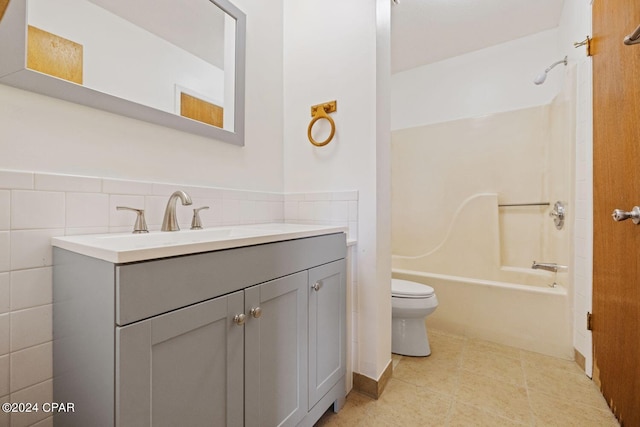 full bathroom featuring shower / washtub combination, toilet, tile walls, vanity, and tile patterned flooring