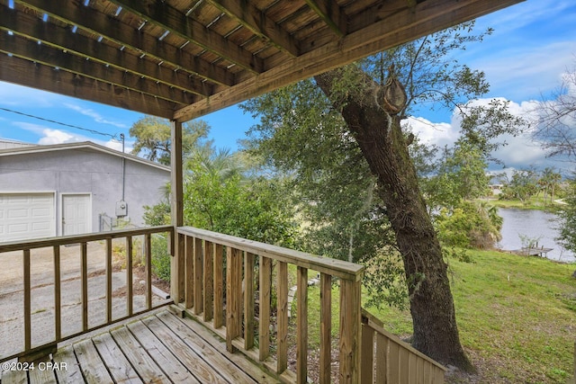 deck with a yard, a garage, and a water view