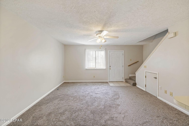 empty room with light carpet, a textured ceiling, and ceiling fan