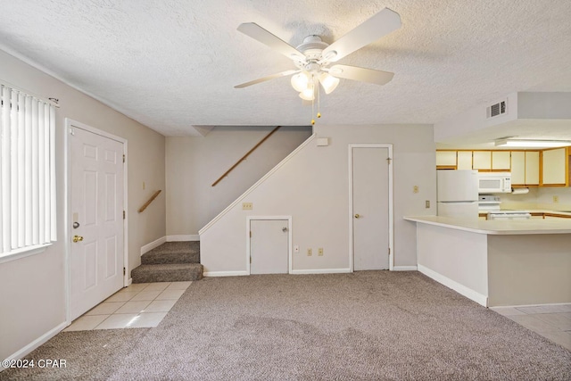 interior space with ceiling fan, a textured ceiling, and light colored carpet