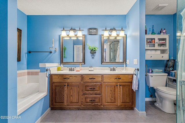 bathroom featuring toilet, a textured ceiling, a bathtub, dual bowl vanity, and tile floors