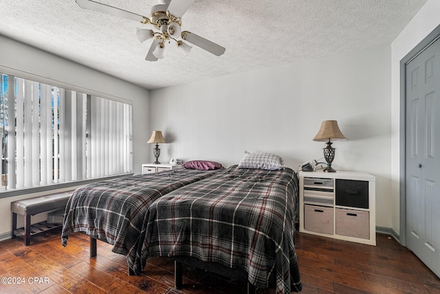 bedroom with a textured ceiling, multiple windows, ceiling fan, and dark hardwood / wood-style flooring