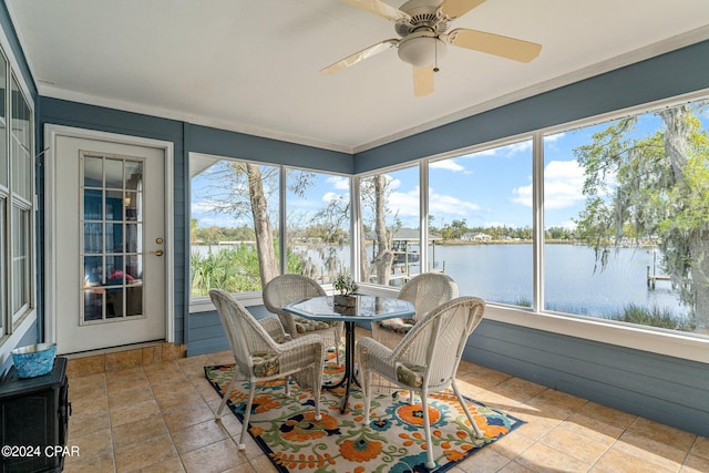 sunroom with a water view and ceiling fan