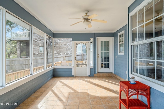 sunroom / solarium featuring a healthy amount of sunlight and ceiling fan