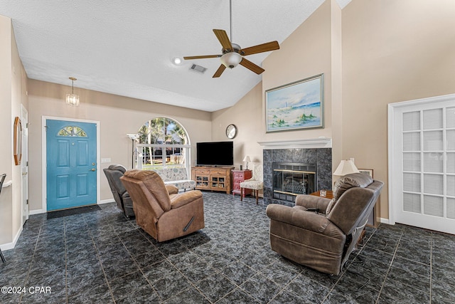 tiled living room with a textured ceiling, a tile fireplace, ceiling fan, and high vaulted ceiling