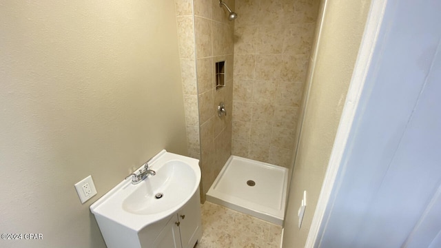 bathroom with vanity and tiled shower