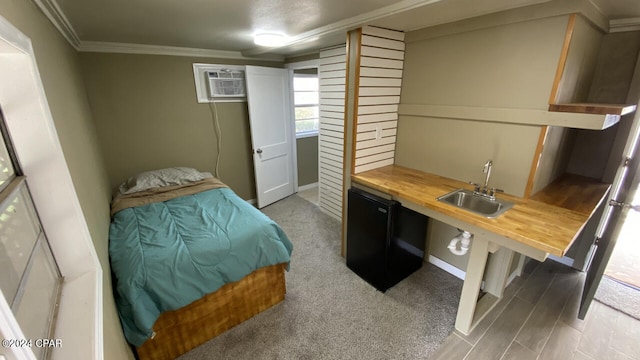 carpeted bedroom featuring crown molding, sink, and a wall unit AC