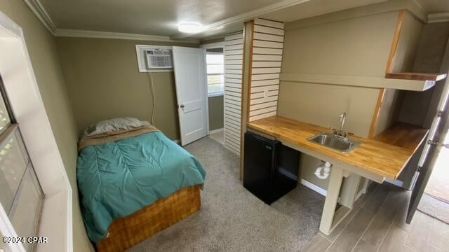 carpeted bedroom with crown molding, a wall mounted AC, and sink