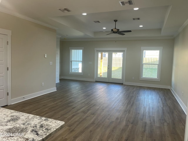 unfurnished living room with a wealth of natural light, dark wood-type flooring, and ceiling fan