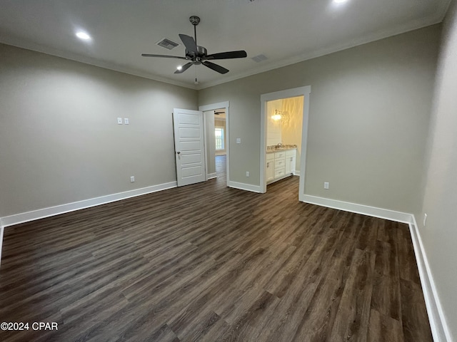 unfurnished bedroom featuring ensuite bath, ceiling fan, dark hardwood / wood-style flooring, and ornamental molding