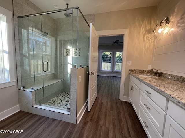 bathroom featuring ceiling fan, vanity, wood-type flooring, and a shower with shower door