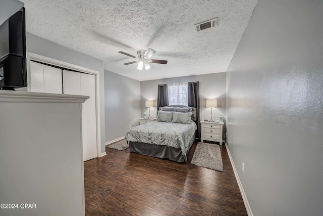 bedroom with ceiling fan, dark hardwood / wood-style flooring, and a textured ceiling