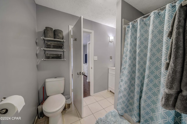 bathroom featuring tile patterned flooring, toilet, and a textured ceiling