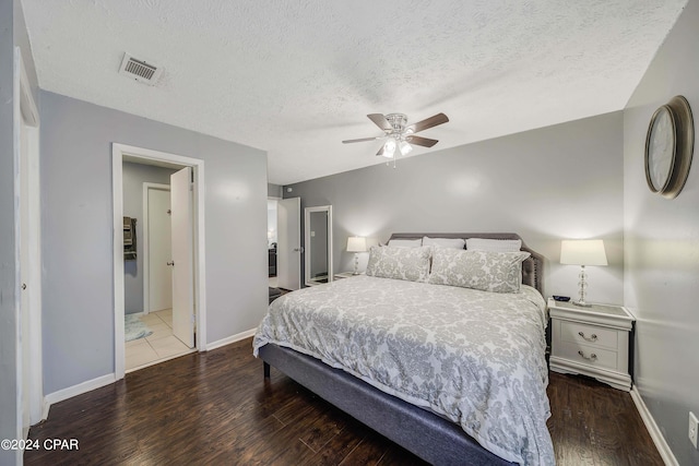 bedroom with a textured ceiling, ceiling fan, and dark hardwood / wood-style floors