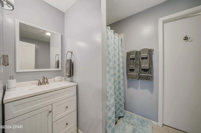 bathroom featuring vanity, a textured ceiling, and tile patterned floors