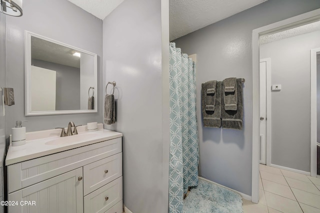 bathroom with vanity, a textured ceiling, and tile patterned flooring