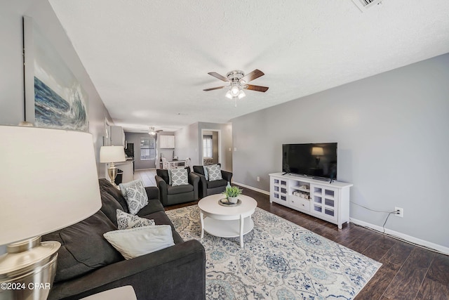 living room with ceiling fan, wood-type flooring, and a textured ceiling