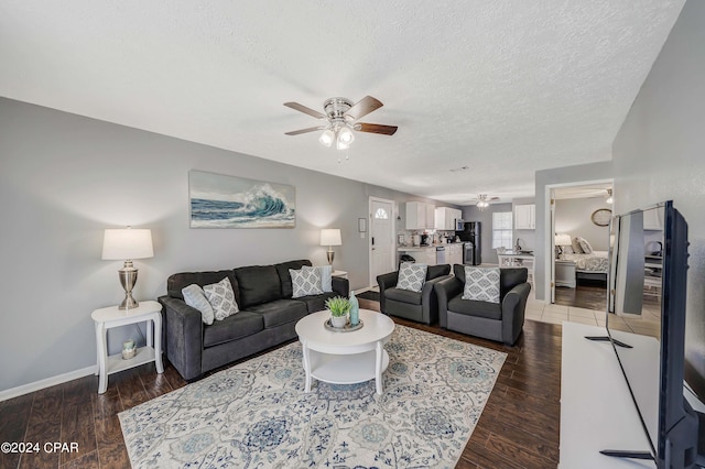 living room with a textured ceiling, wood-type flooring, and ceiling fan