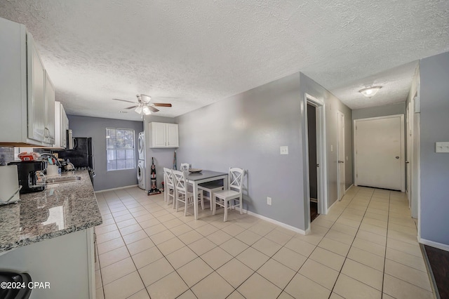 kitchen featuring a textured ceiling, light stone countertops, ceiling fan, and white cabinets