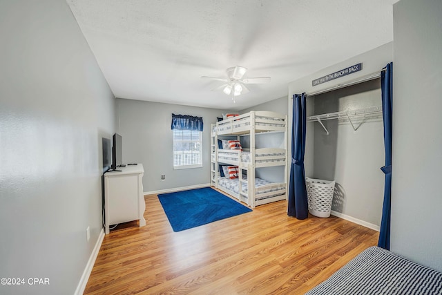 unfurnished bedroom with light hardwood / wood-style flooring, ceiling fan, and a closet