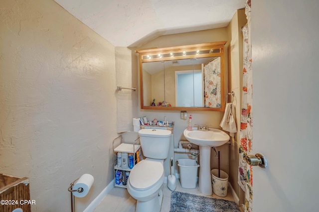 bathroom featuring vaulted ceiling, toilet, sink, and tile patterned flooring