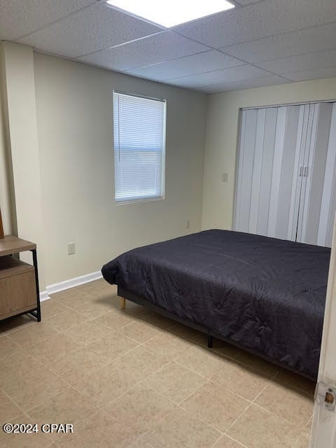 tiled bedroom featuring a paneled ceiling