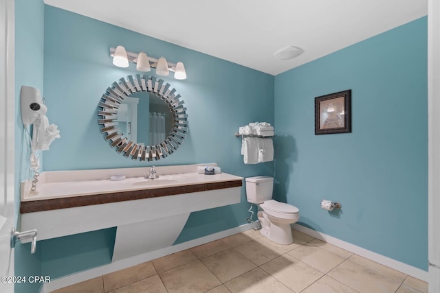 bathroom with toilet, tile floors, and sink