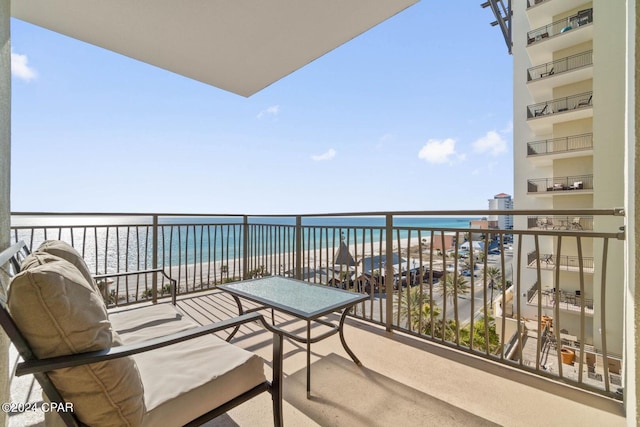 balcony featuring a view of the beach and a water view