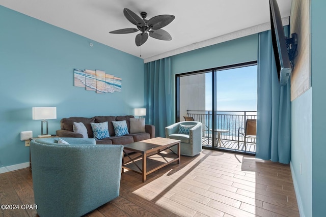 living room with a water view, wood-type flooring, and ceiling fan