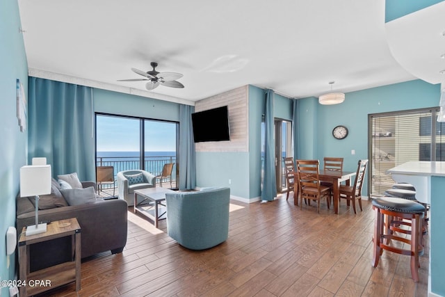 living room featuring a water view, ceiling fan, and dark hardwood / wood-style floors