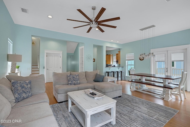 living room with hardwood / wood-style floors, french doors, and ceiling fan