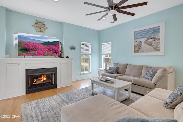 living room with light hardwood / wood-style flooring and ceiling fan