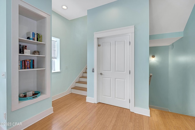 interior space with built in shelves and wood-type flooring