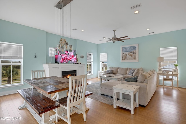 living room featuring plenty of natural light, ceiling fan, and light wood-type flooring