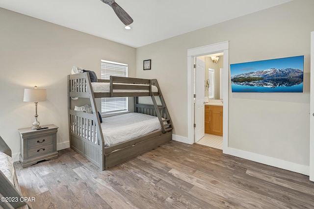 bedroom with hardwood / wood-style floors, ensuite bath, and ceiling fan