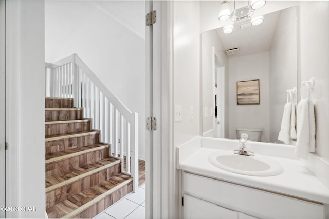 bathroom with tile patterned flooring, vanity, and toilet