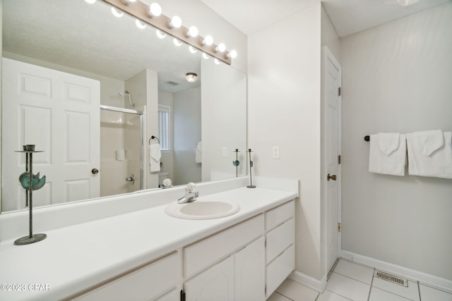 bathroom featuring vanity, tile patterned floors, and walk in shower